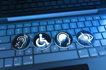 Teclas de um notebook com quatro símbolos de acessibilidade: audição, mobilidade, deficiência intelectual e deficiência visual.