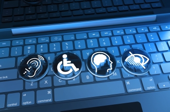 Teclas de um notebook com quatro símbolos de acessibilidade: audição, mobilidade, deficiência intelectual e deficiência visual.