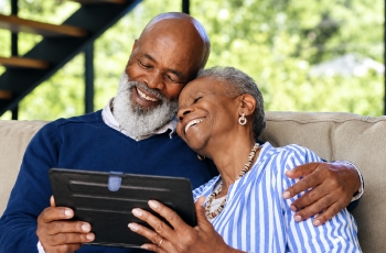 um homem e uma mulher idosos sentados em um sofa