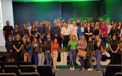 Grupo de pessoas sobre um auditório posando para foto