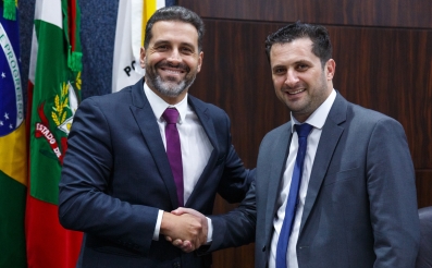 Dois homens de terno dando as mãos em cumprimento