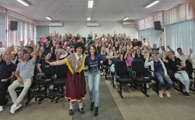 Foto de um auditório cheio de trabalhadores homens e mulheres celebrando.