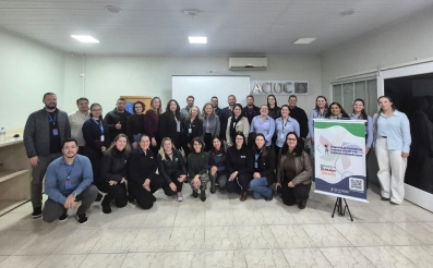 Grupo de 30 pessoas reunidas posam para foto na sede da ACIOC