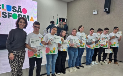 Mulher posa com 10 jovens lado a lado. Todos eles exibem um certificado.