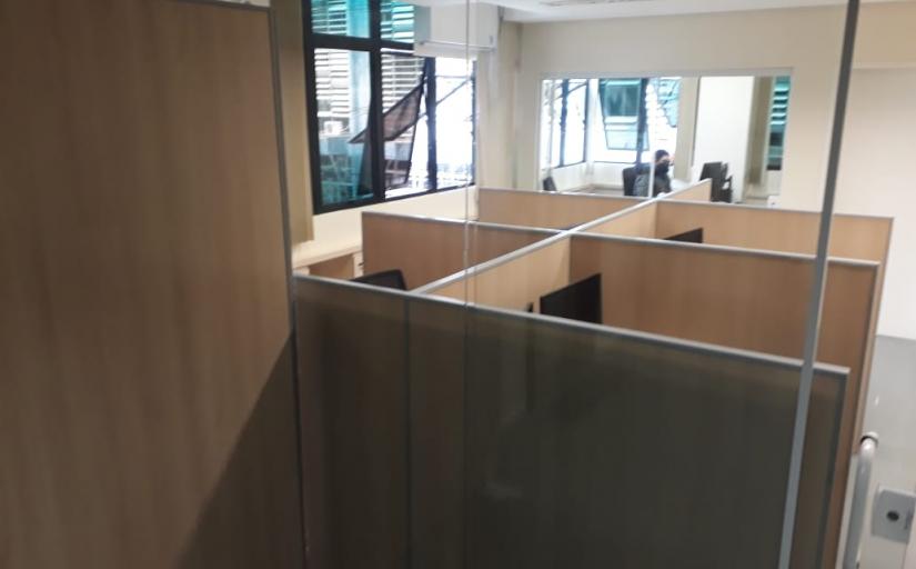 Imagem da sala de coworking do TRT-SC, com dois postos de trabalho ladeados e separados por uma face de madeira