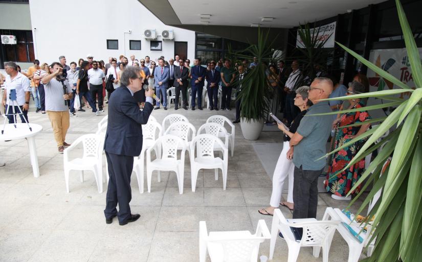 Homem de terno discursando na frente de muitas pessoas ao ar livre