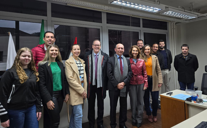 Fotografia de um grupo de doze pessoas, sendo cinco mulheres e sete homens, em pé, nas instalações internas da vara do trabalho de Joaçaba