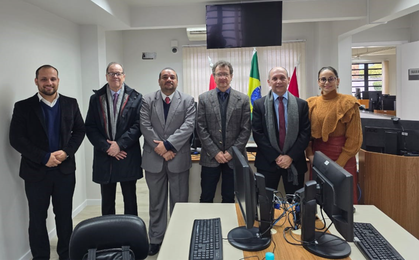 Fotografia de um grupo de seis pessoas, sendo 5 homens e 1 mulher, em pé, nas instalações internas da vara do trabalho de Concórdia