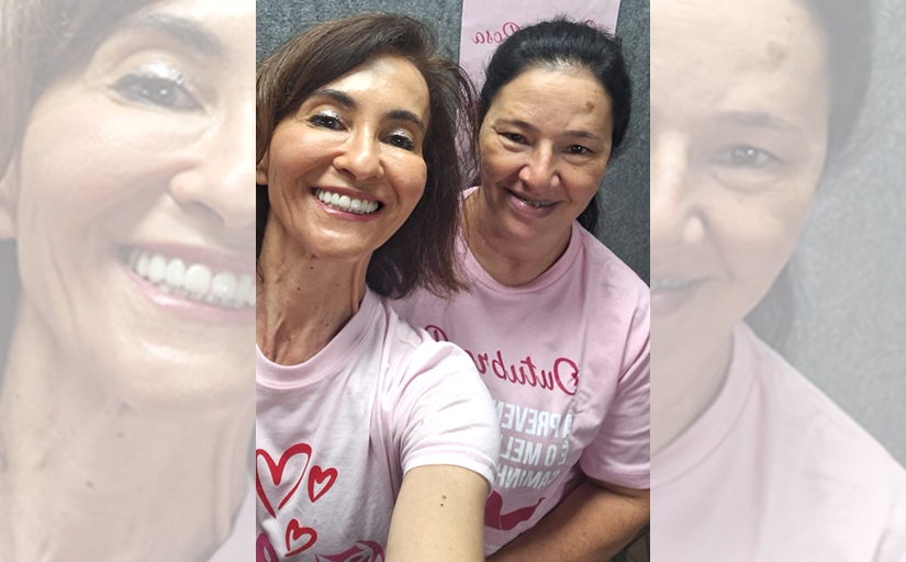 Duas mulheres sorrindo vestindo camiseta rosa